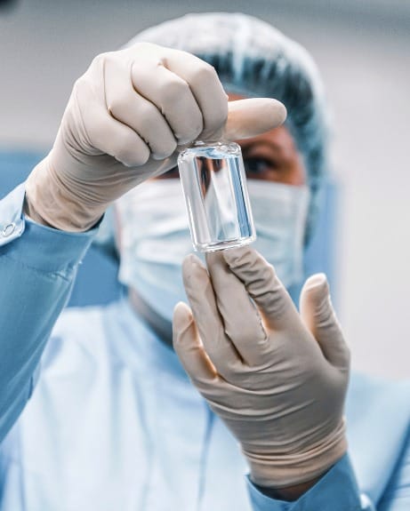 Clinician carefully inspecting a regenerative biologic vial